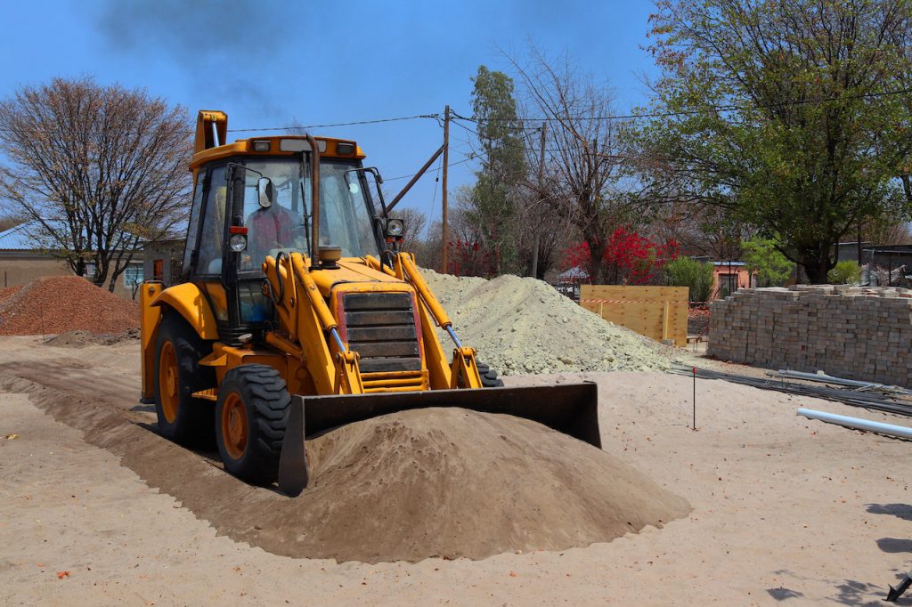 yellow bulldozer picking up gravel