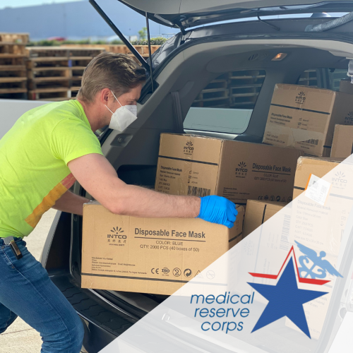 Volunteer placing supply boxes into car