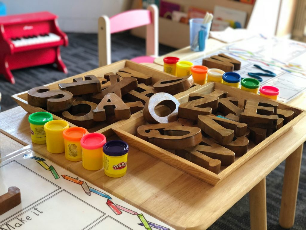 Photo of table with play-doh and wooden block letters